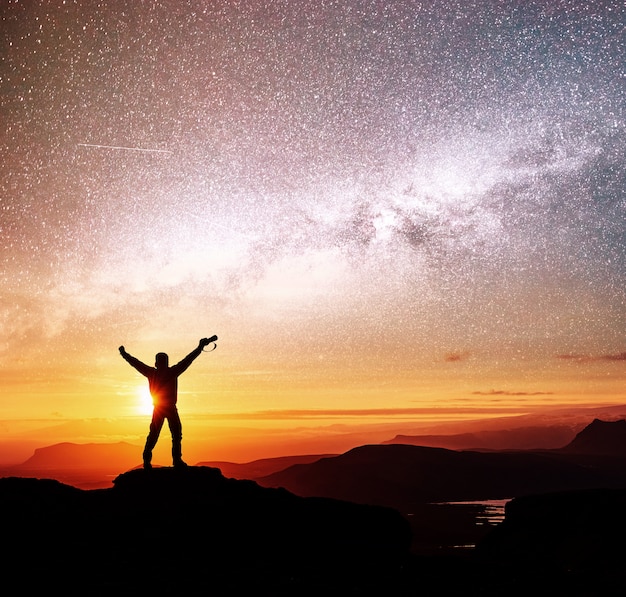 Free Photo silhouette of woman is standing on top of mountain and pointing to the milky way before sunrise and enjoying with colorful night sky