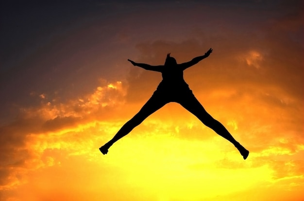 Free photo silhouette of woman jumping at sunset