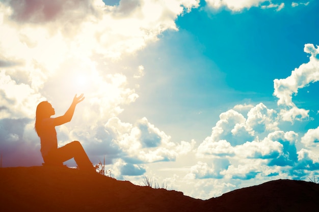 Silhouette of woman with raised hands