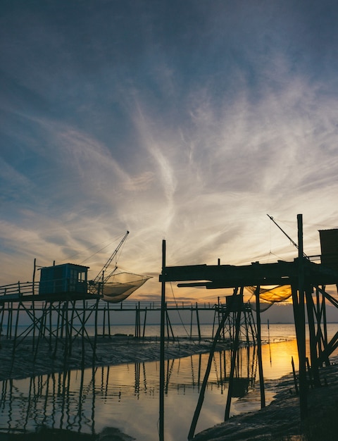 Free photo silhouette of wooden stands near the sea during sunset