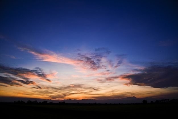 Silhouettes of hills under a cloudy sky during a beautiful sunset