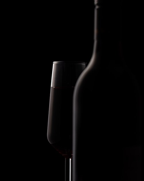 Silhouettes of wine bottle and wine glass on black