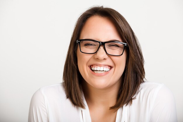 Silly cute adult woman in glasses laughing