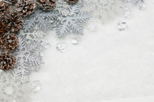 Silver Christmas snowflakes and pine cones nestled in ice