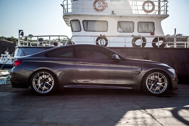 A silver luxury sedan parked in the port.