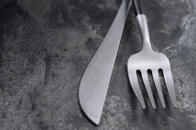 Silver modern cutlery on stone background. Closeup