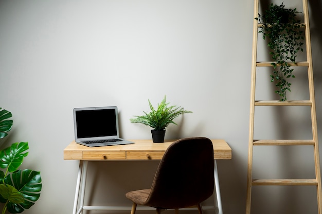 Free photo simple desk with chair and grey laptop