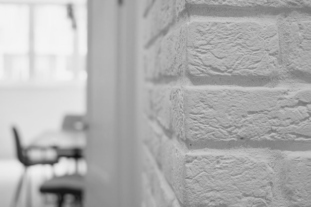 Simple room interior with white brick wall and furniture on blur room background, loft style studio design idea, minimalistic design, reasonable simplicity of interiors