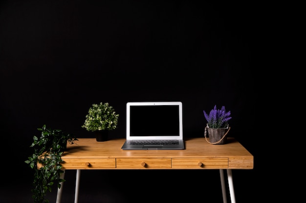 Free photo simple wooden desk with gray laptop