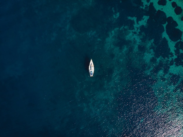 Free Photo single boat in the middle of clear blue sea