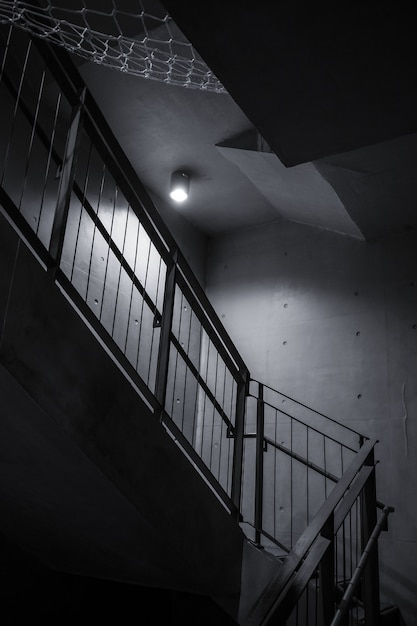 Single light bulb illuminating interior dark staircase