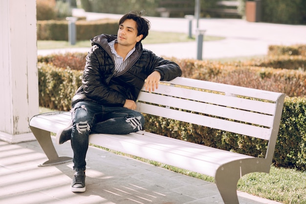 Single man sitting on the bench in the park and thinking. High quality photo