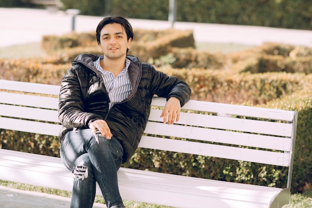 Single man sitting on the bench in the park and thinking. High quality photo