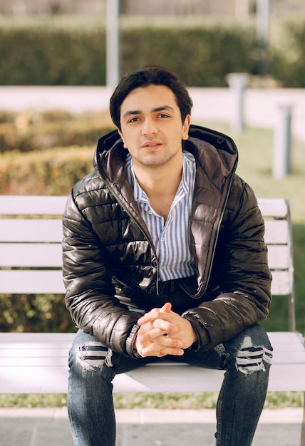 Single man sitting on the bench in the park and thinking. High quality photo