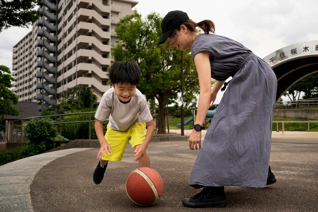 Single mom playing basketball with her son