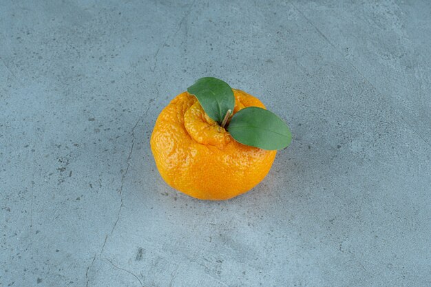 A single of ripe tangerine , on the marble background. High quality photo