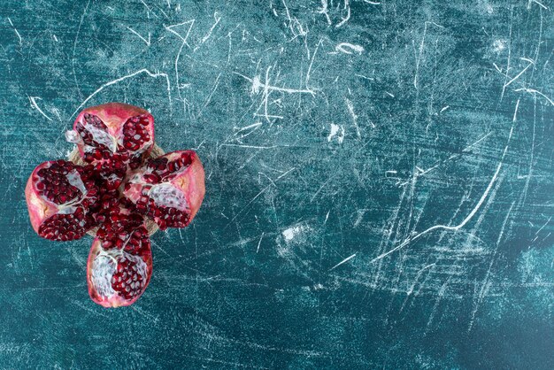 Single sliced of pomegranate on the blue background. High quality photo