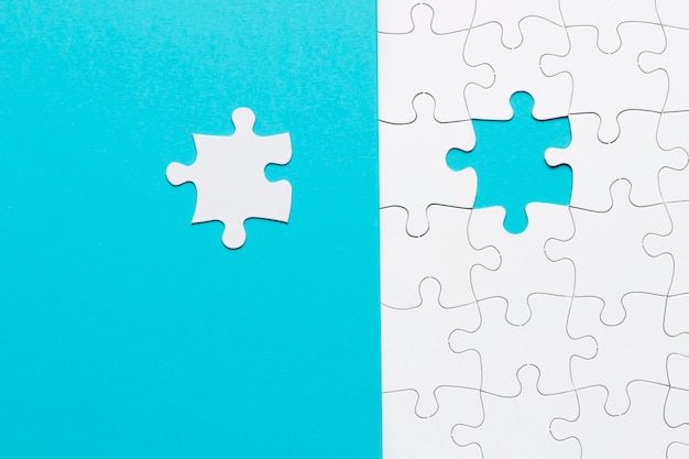 Free Photo single white jigsaw puzzle piece on blue background