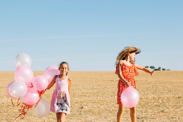 Free photo sisters having fun with balloons