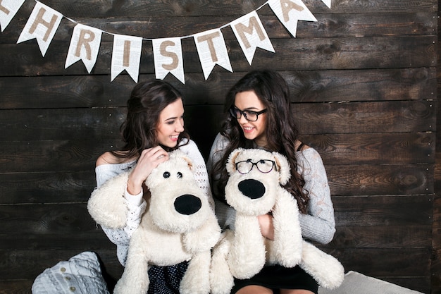 Sisters smiling with their cuddly dogs