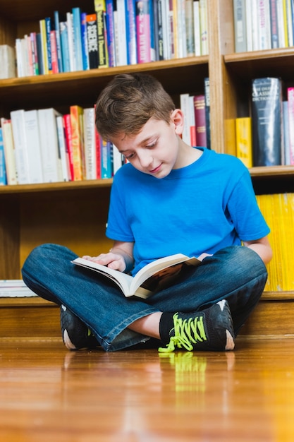 Sitting on floor excited boy reading book 