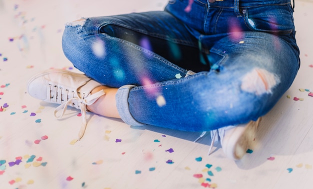 Free photo sitting on the floor surrounded by confetti