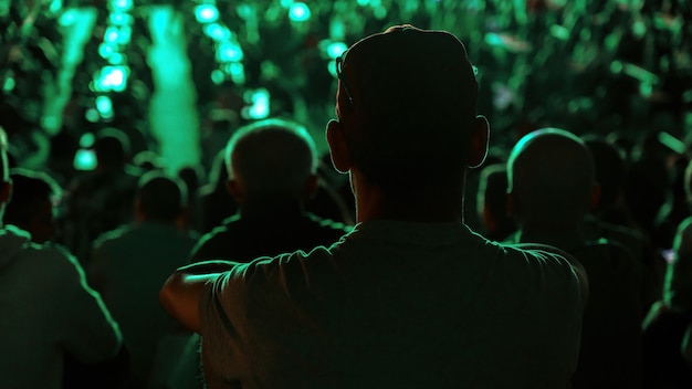 Free Photo sitting man watching football in a public place at night