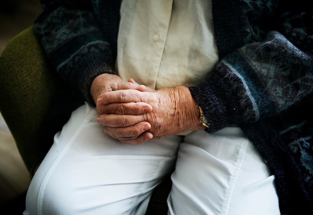 Free photo sitting senior man close up on his holding hands