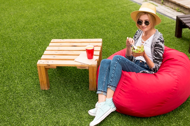 Free photo sitting woman enjoying a salad