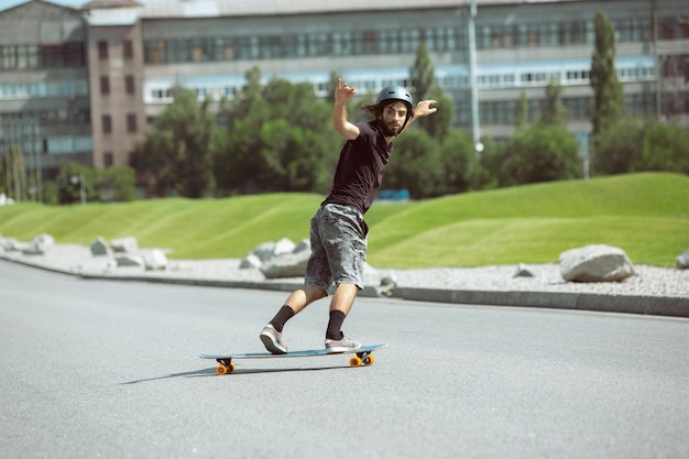 Skateboarder doing a trick at the city's street in sunny day.