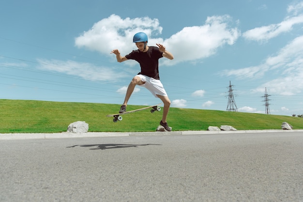 Free photo skateboarder doing a trick at the city's street in sunny day.