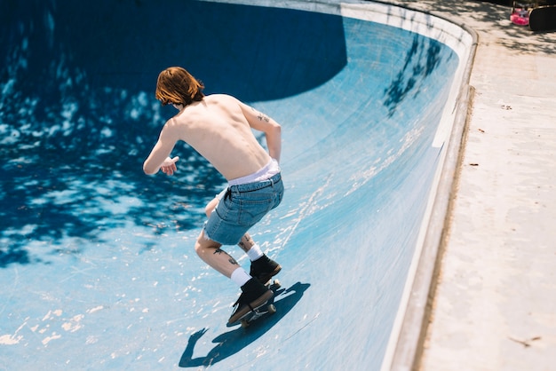 Skateboarder riding in sunny day