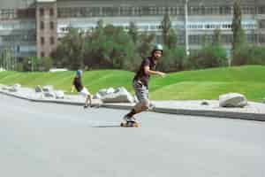 Free photo skateboarders doing a trick at the city's street in sunny day