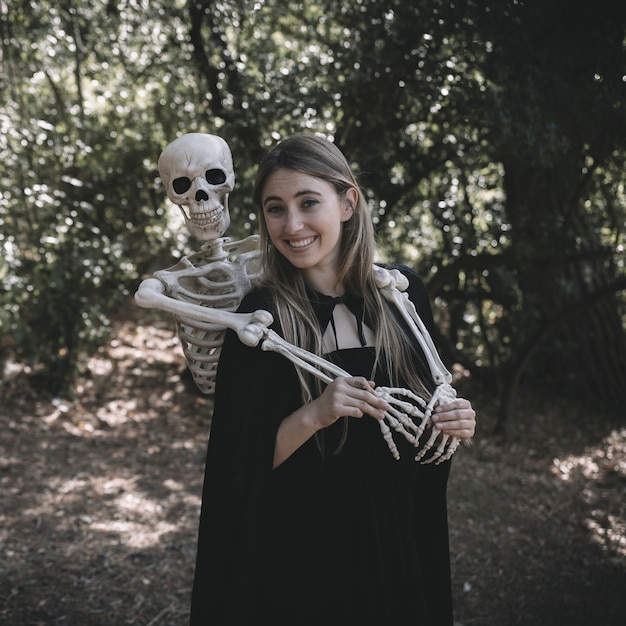 Free photo skeleton standing behind laughing happy lady