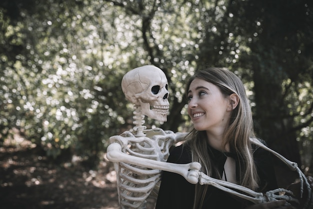 Free Photo skeleton standing near laughing lady