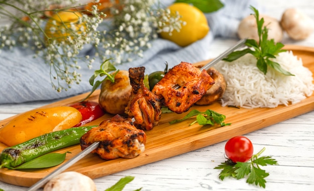 Free photo skewered chicken kebab with rice and vegetables