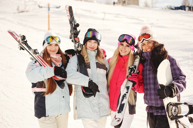 Free Photo ski equipment in hands of girls. bright colors on ski clothes. girls have a good time together.