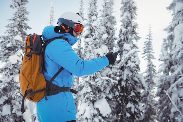 Skier using mobile phone on snowy mountains