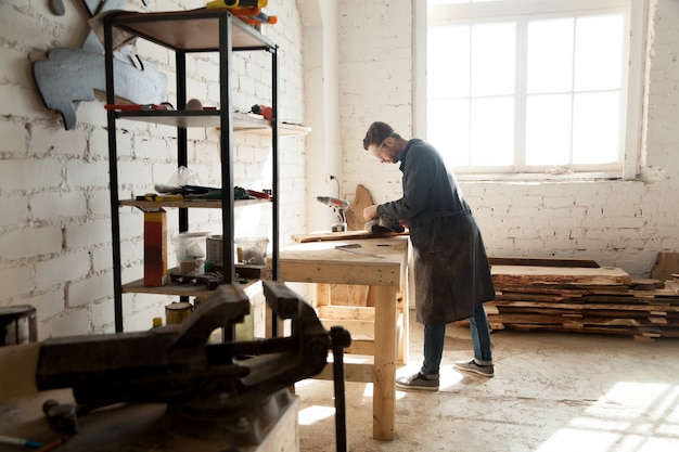 Free photo skilled self-employed carpenter working with wood in carpentry workshop interior