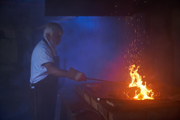 Free Photo skillful blacksmith heating steel over burning fire