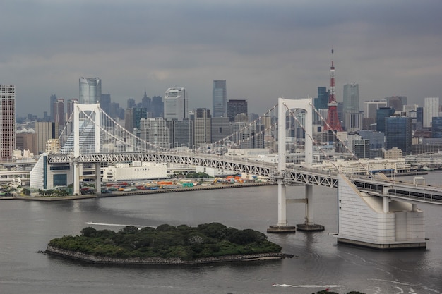 Free photo skyline of a minato city high-rise buildings near a rainbow suspension bridge in tokyo, japan