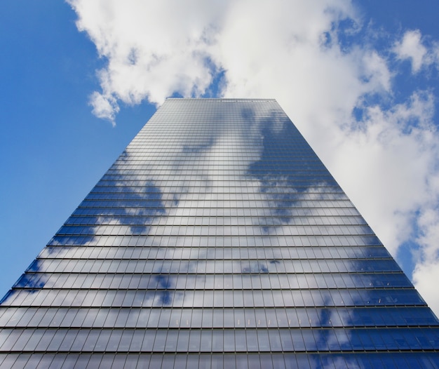 Free photo skyscraper with clouds reflection