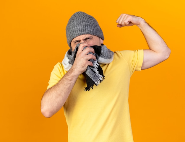 Free photo slavic man wearing hat and scarf puts hand on neck