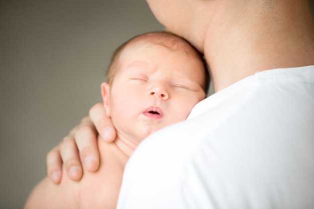 Free Photo sleeping newborn at the male shoulder