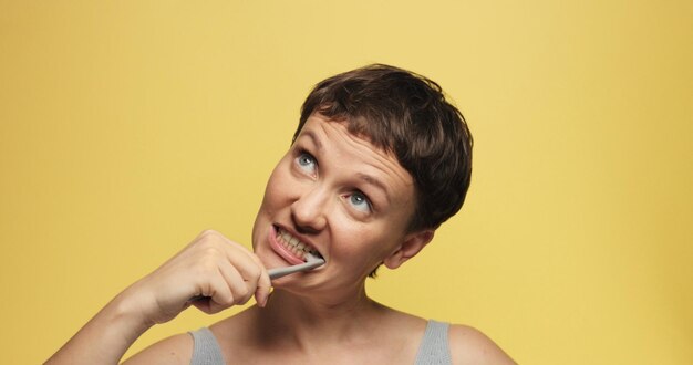 Sleepy 30s woman with a short haircut on a yellow morning atmosphere background