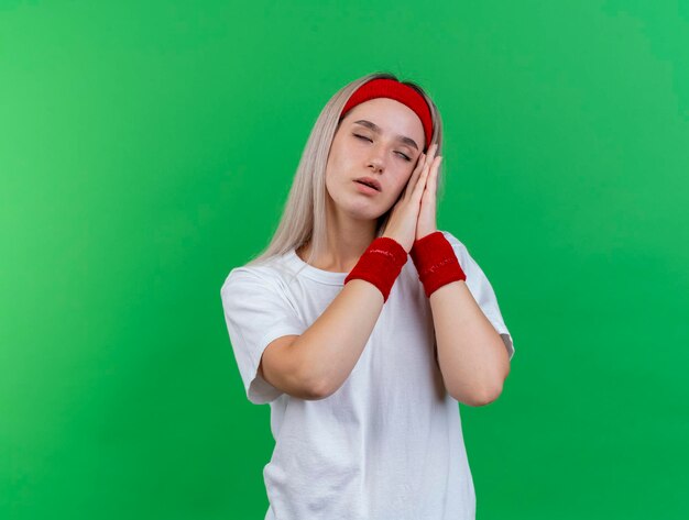 Sleepy young caucasian sporty girl with braces wearing headband