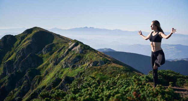 Slender woman doing yoga exercise on fresh air