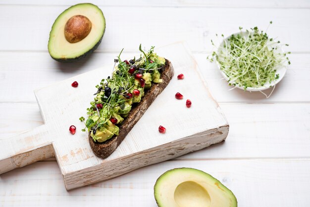 Slice of bread with avocado pasta and pomegranate high view