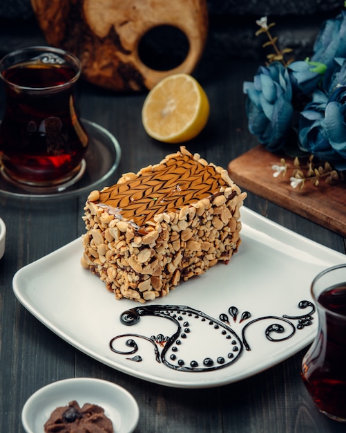 Free Photo a slice of cake with caramel sauce decoration and peanuts.