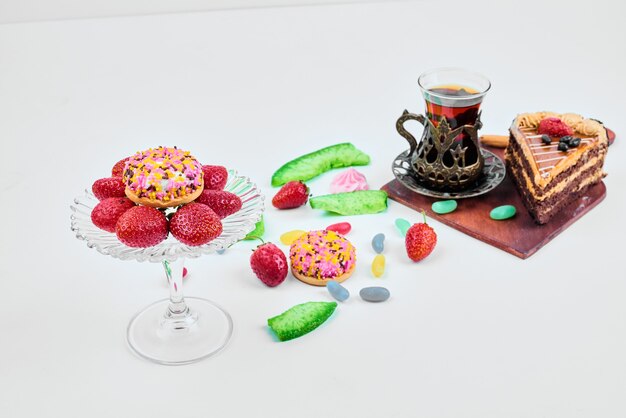 A slice of cake with fruits and tea.